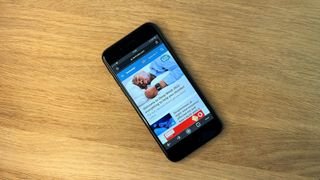 iPhone SE 2022 قيد الاستخدام على خلفية خشبية