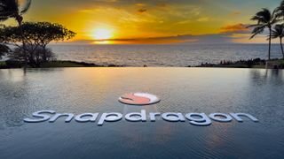 علامة Snapdragon وشعارها في حمام سباحة لا متناهي مع غروب الشمس في هاواي خلفها