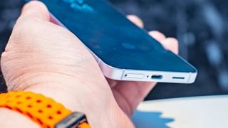 Samsung Galaxy S25 from angle in hand showing bottom part of screen and USB-C port with SIM tray