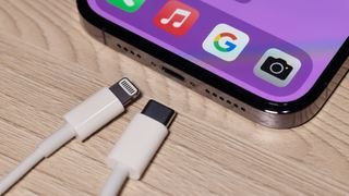 شاحن البرق وشاحن USB-C بجوار جهاز iPhone 14