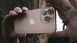 يديان يحملان iPhone 16 Pro يعرض كاميراته