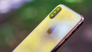 iPhone XS على خلفية خوخه في الهواء الطلق