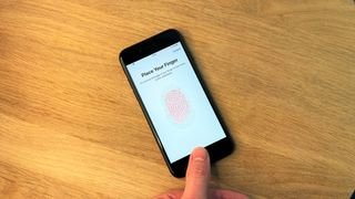 يستخدم iPhone SE 2022 على خلفية خشبية