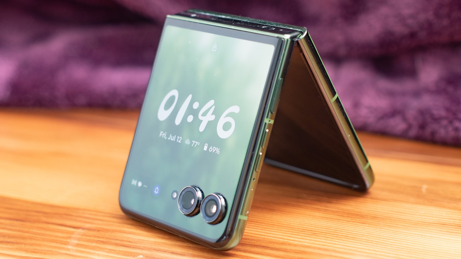Motorola Razr Plus 2024 باللون الأخضر يقف مثل خيمة مع ساعة على وجهها
