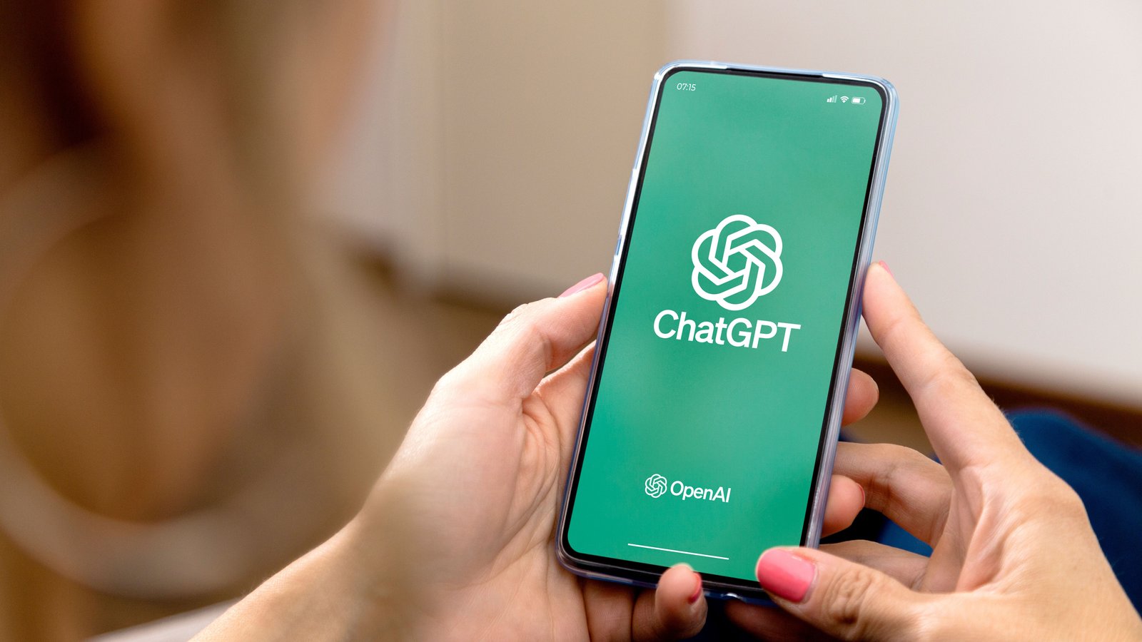 امرأة تستخدم هاتفًا محمولًا مع ChatGPT على الشاشة.