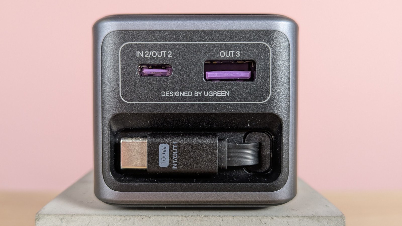 عن قرب من الموانئ وتراجع كابل USB-C على Ugreen Nexode Bank 20000mah 165w ، على طيبة على مكتب مع خلفية وردية