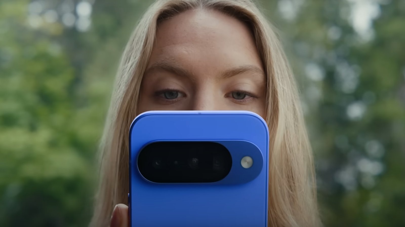 امرأة تنظر إلى هاتف Google Pixel الأزرق 10