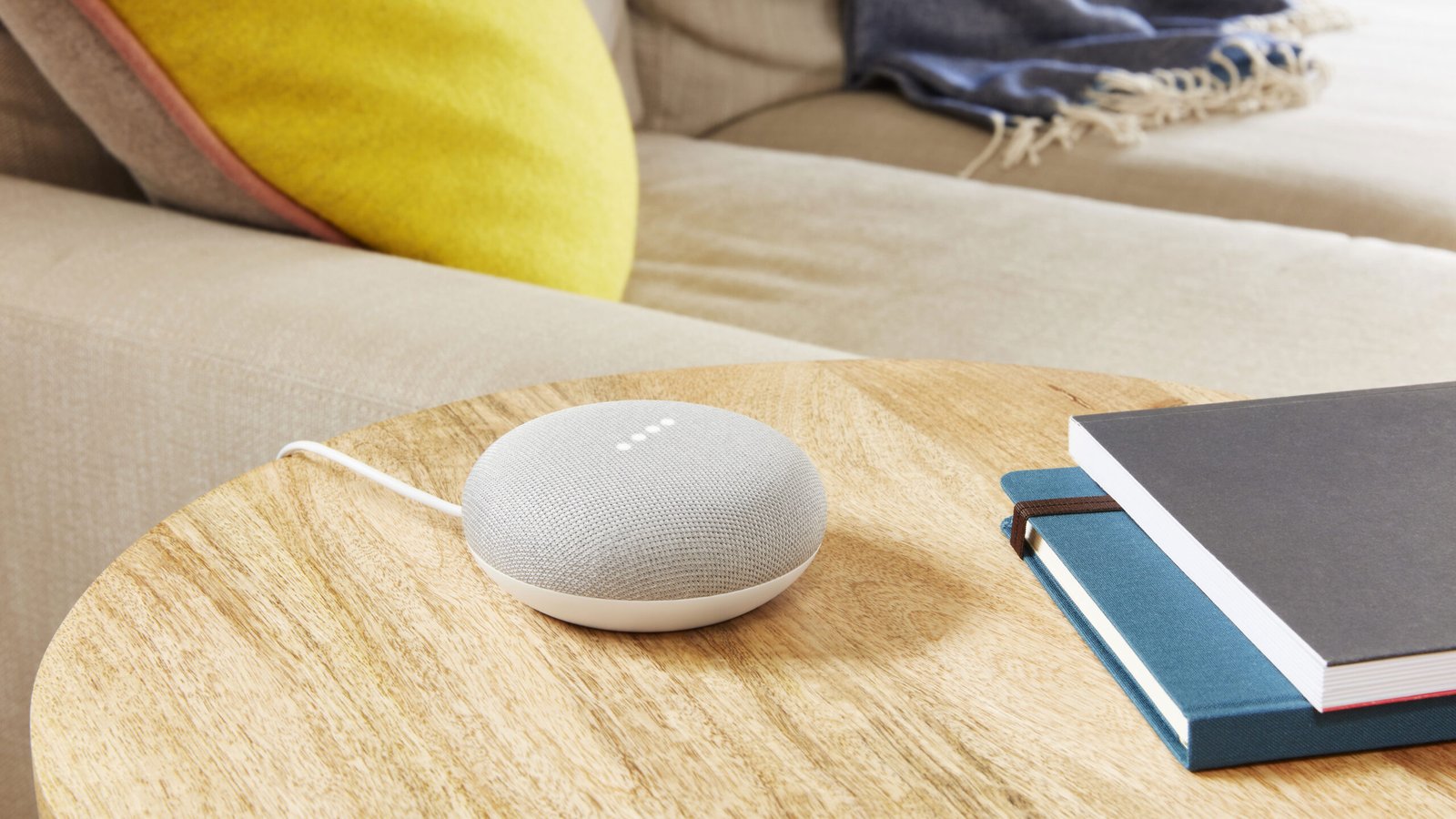 Google Nest Mini speaker on table with books