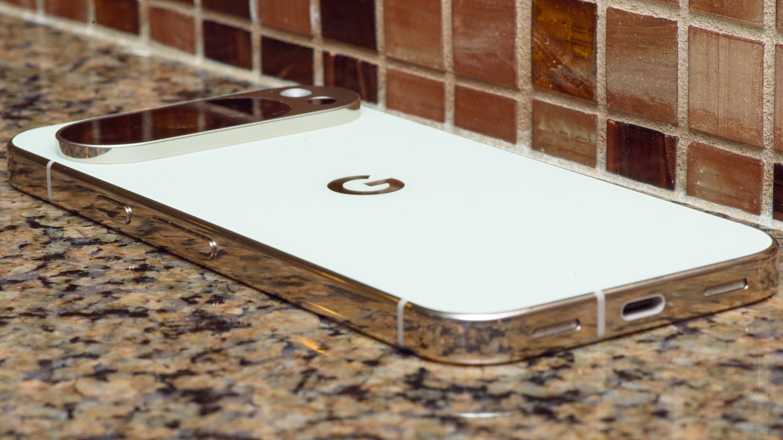 Google Pixel 10 Pro in Jade with checkered tile backsplash background