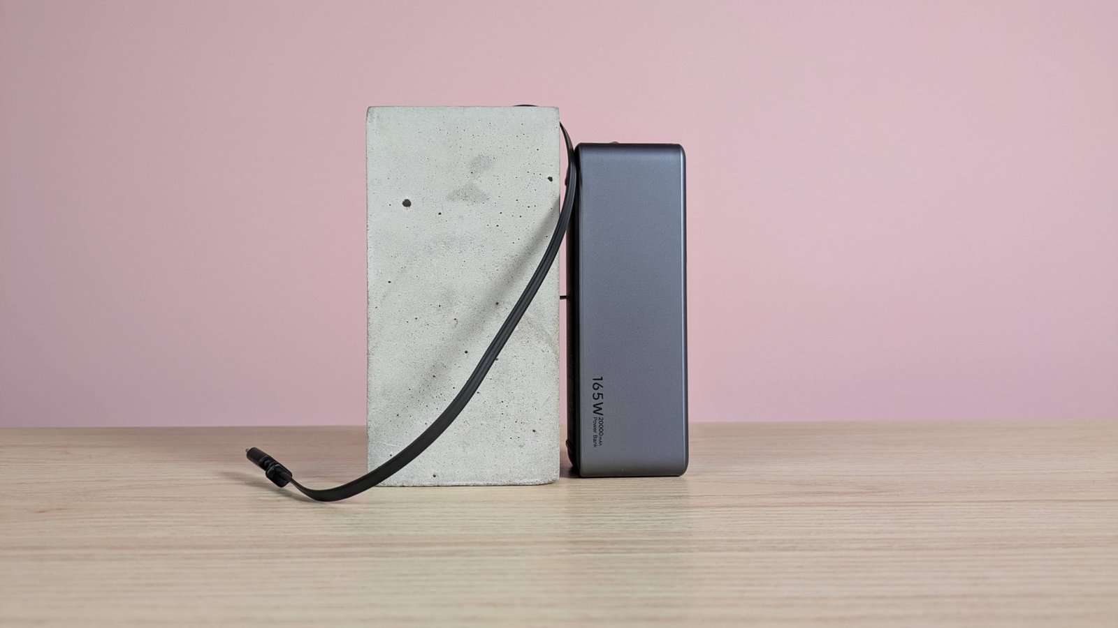 Ugreen Nexode Bank 20000mah 165w يميل على اللقطة مع سحب كابل USB-C في مكتبه ، على مكتب مع خلفية وردية